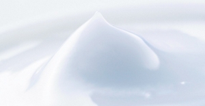 A close-up image of a white, creamy, and soft cosmetics liquid resembling a lotion.