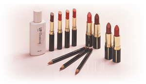 One pink bottle that reads, “LIP Cleansing”, and many shades of open lipstick cases surrounding three lip liner pencils lying flat.