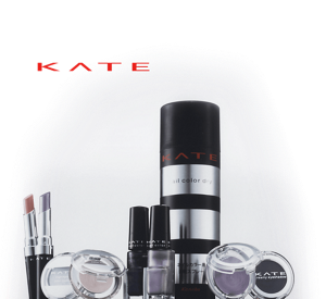 A wide variety of KATE cosmetics products in black and silver packaging against a grey background and “KATE” written in red.