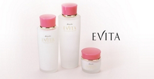 Three white cosmetics bottles of various sizes with pink lids and text on the right that reads, “EVITA”.