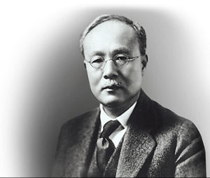 A monochromatic portrait of Muto Sanji, an early president of Kanebo, wearing glasses and a suit, looking directly into the camera.