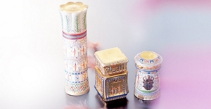 Three luxury cosmetics in unique packaging materials of various sizes that resemble ancient, Egyptian murals and art works.