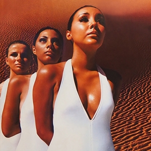 Advertising poster for “Blan-Tan-Lu” featuring six women with tanned complexions in the dessert wearing matching white leotards.