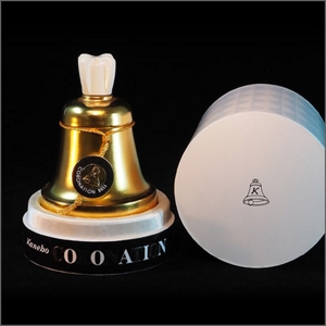 Open packaging for perfume, Coronation Bell (1964), featuring a bottle in the shape of a gold bell containing the perfume.