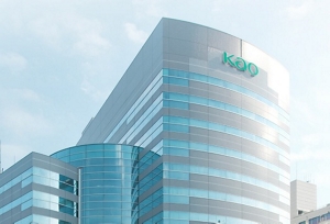 A modern office building with the word, “Kao” written on top in green.