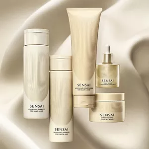 Fünf Haarpflegeprodukte vor einem fließenden, beige-goldenen Hintergrund mit sanften Wellen