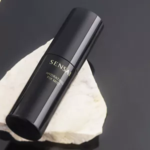 Black spray bottle showcased on black surface.