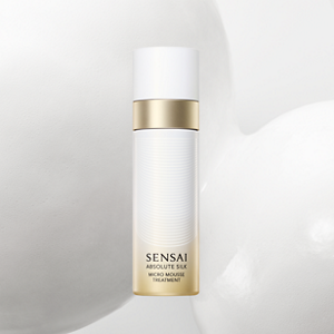 Absolute Silk Micro Mousse Treatment bottle displayed against a white foamy background