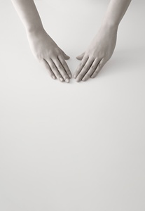 Deux mains positionnées paume vers le bas, prêtes à débuter une routine de soins de la peau.
