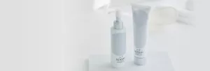 En hvit rensetube og dispenserflaske mot en hvit bakgrunn.