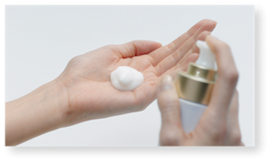 Micro Mousse Treatment dispensed onto palm, bottle held in right hand