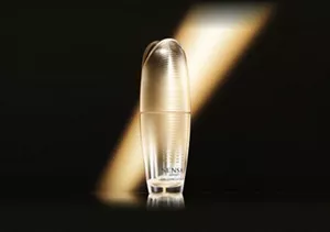 UTM ザ コンセントレート Nのボトルイメージ:暗い背景に金色の一筋の光がある背景に金色のボトルが置かれている