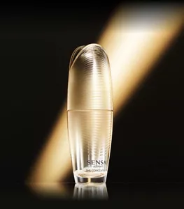 UTM ザ コンセントレート Nのボトルイメージ:暗い背景に金色の一筋の光がある背景に金色のボトルが置かれている