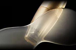 UTM ザ コンセントレート Nのボトルイメージ:黒い背景に浮かび上がる、金色に輝く光に照らされた輝く金色の瓶。