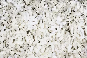Close-up image of a mass of white chips identified as non-recyclable materials.