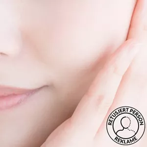 Nærbilde av den nedre delen av en kvinnes ansikt, med en hånd som berører kinnet