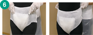 6.紙パンツの前側を引き上げた後、両横を引き上げている画像。