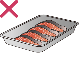 魚の切り身を金属製のバットの上に置き、常温で解凍している様子のイラスト。