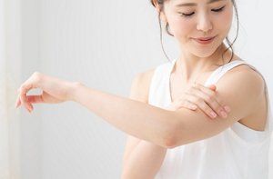 ボディに日やけ止めを塗る女性