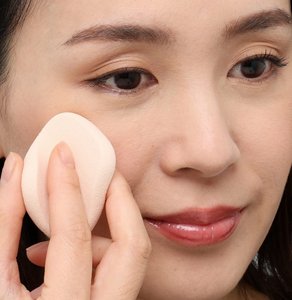 必要箇所にベースメイクを薄くのせる女性の画像