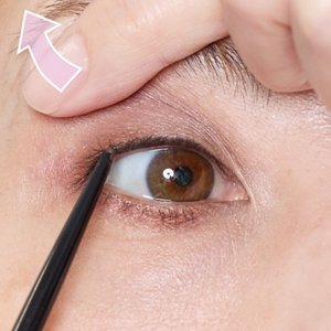 空いた手でまぶたを軽く引き上げてまつ毛の根もとを埋めている画像