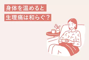「身体を温めると生理痛は和らぐ?」のタイトル画像。毛布でお腹を温める女性のイラストイメージ
