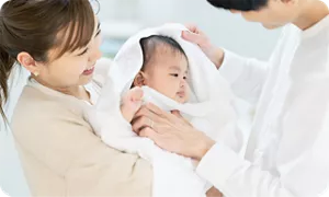 ママとパパに体を拭いてもらっている赤ちゃん