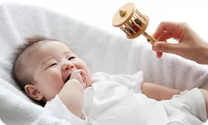 ガラガラを見て笑顔の赤ちゃん