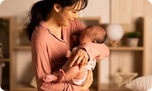 夜泣きした赤ちゃんをなだめるママ