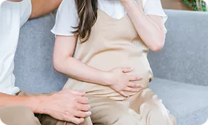 おなかに手を当てる妊婦