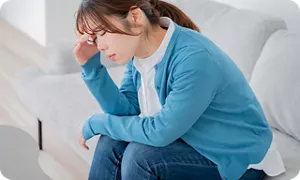 頭痛がつらい様子の妊婦