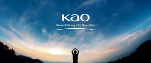 Silhouette of a person against a bright blue sky with wispy white clouds. Their arms are up and their hands are forming the shape of a heart. Kao's logo with the tagline Kirei-Making Life Beautiful is in the center.