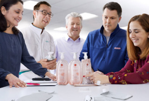 Diverse group of 5 KAO employees looking at various packaging samples from the My Kirei by KAO line of products.