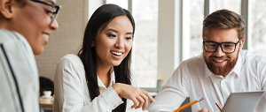 Three diverse coworkers in a meeting discussing what they are looking at a computer screen.