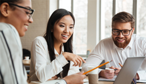 Three diverse coworkers in a meeting discussing what they are looking at a computer screen.
