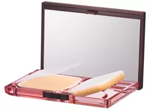 Photograph of a compact container. A film for keeping the mirror clean is attached at one end, and opening the lid raises the sponge