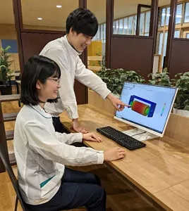 Two researchers discussing while looking at the analysis results.