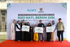 Foto perwakilan Kao Indonesia bersama BAZNAS dan anak-anak yatim foto bersama memegang papan serah terima dukungan