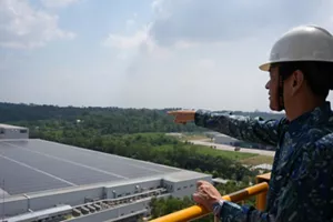 Photo of Mr. Soichi Hasegawa, President Director of Kao Indonesia, looking at and pointing to the Solar Power Plant area at the Karawang Plant.
