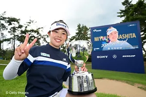 優勝トロフィーを掲げてピースサインをする山下選手