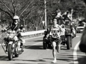 写真:先導のバイクや車に囲まれて走っている様子