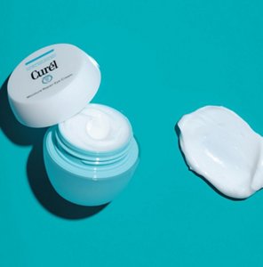 Pot of Curel eye cream against a teal background