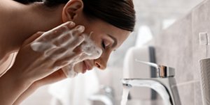 Woman using a foaming facial wash to clean her skin