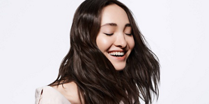 Smiling woman with dark brown hair and bright background