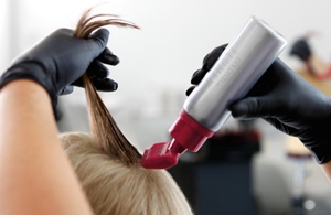 A woman is at the hairdresser for the goldwell elumen full-head color service to refresh, intensify and enhance her existing hair color.