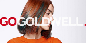 Woman with red and green hair in front of bright background and Go Goldwell logo in front