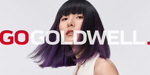 Woman with black and green hair in front of bright background and Go Goldwell logo in front