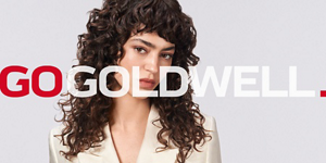 Woman with red and green hair in front of bright background and Go Goldwell logo in front