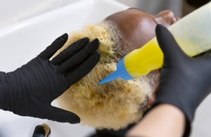 uski kadar frizera koji tonira celu kosu žene sa Goldwell Iridescent Blonde proizvodom