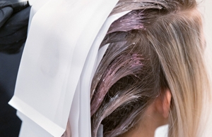 uski kadar frizera koji tehnikom shine toning tonira kosu žene sa Goldwell Iridescent Blonde proizvodom